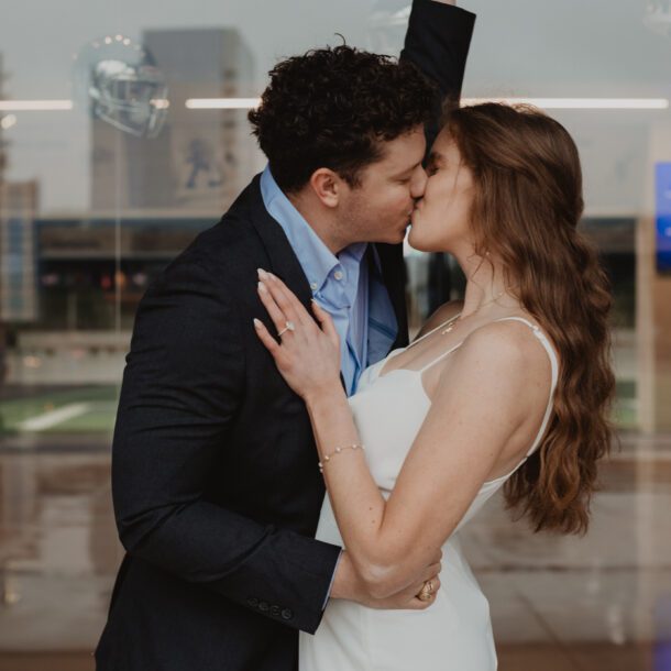 Couple celebrating engagement outside AT&T Stadium — Captured by Bushel + Peck Photo, Dallas Proposal Photographer