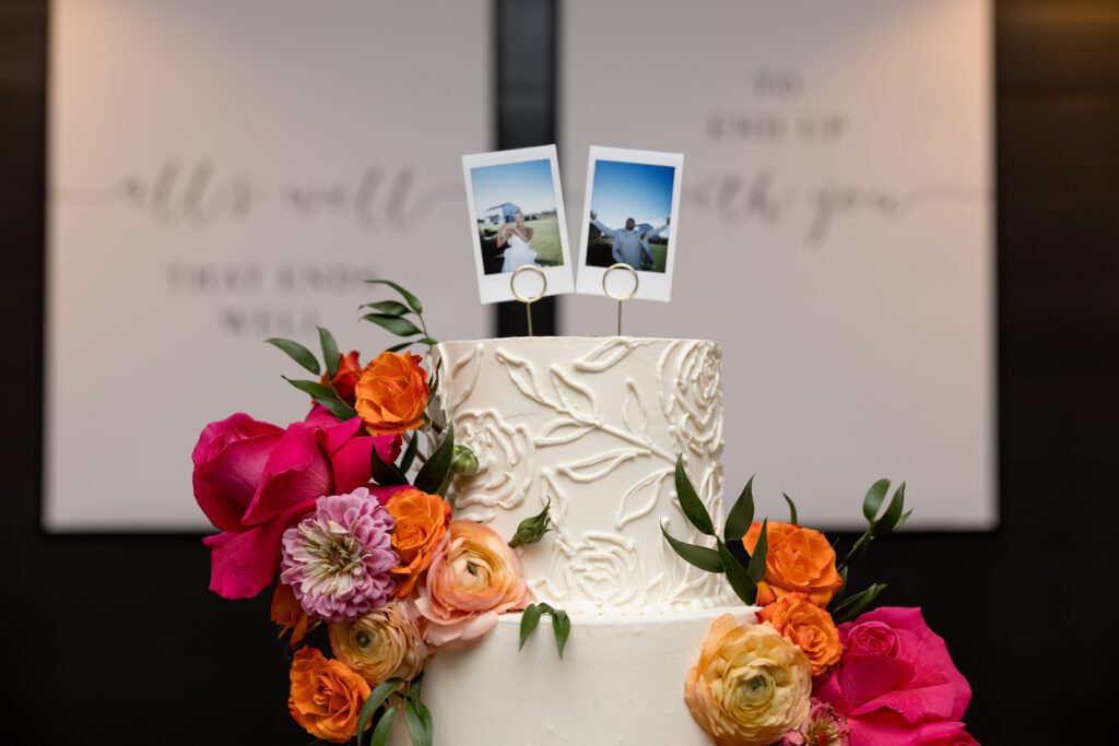 a cake with flowers and polaroid pictures on top