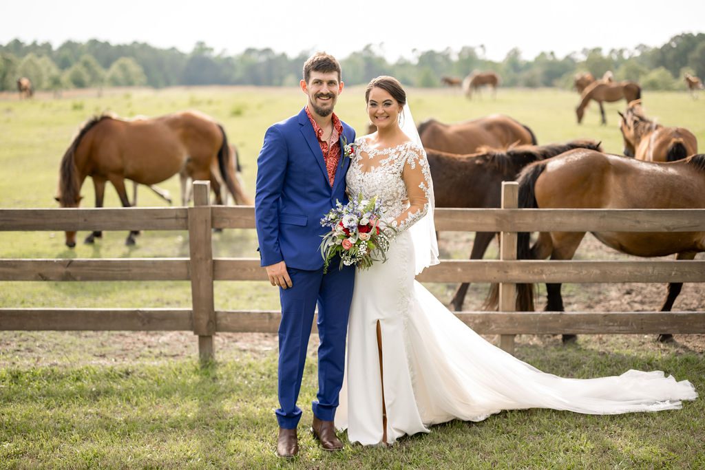 a man and woman in wedding attire posing for picture with horses