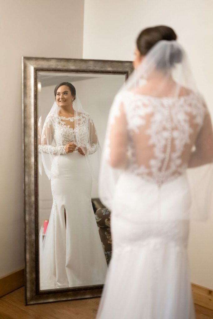 a woman in a white dress looking at a mirror , 7 Must-Have Steps for the Ultimate Wedding Photography Poses Checklist