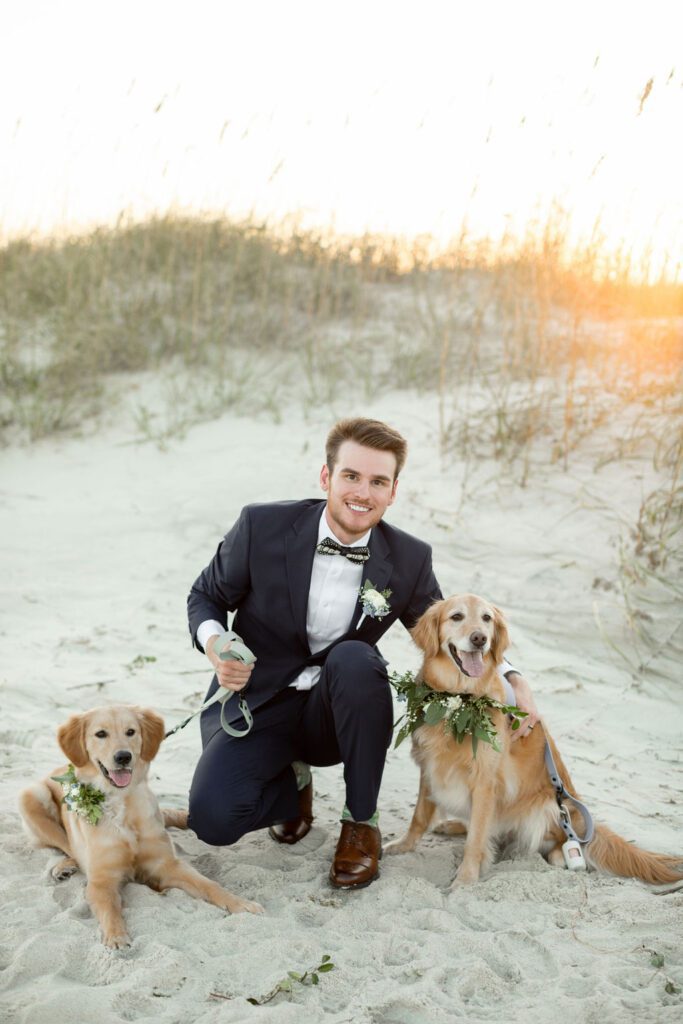 a man in a suit and tie with two dogs on a beach , 8 Tips for Incorporating Pets into Your Wedding Photos