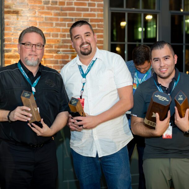 Three colleagues posing with drinks at a corporate holiday party, captured by Bushel + Peck Photo