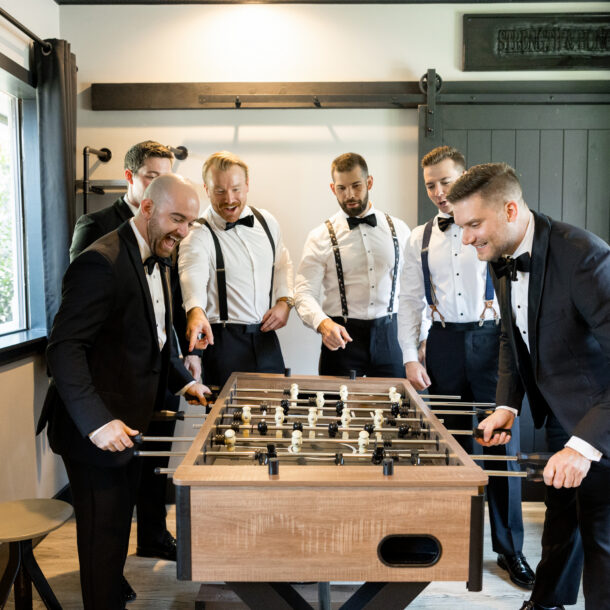Groomsmen getting ready and playing foosball at Brighton Abbey wedding venue near Dallas photographed by Bushel + Peck Photo
