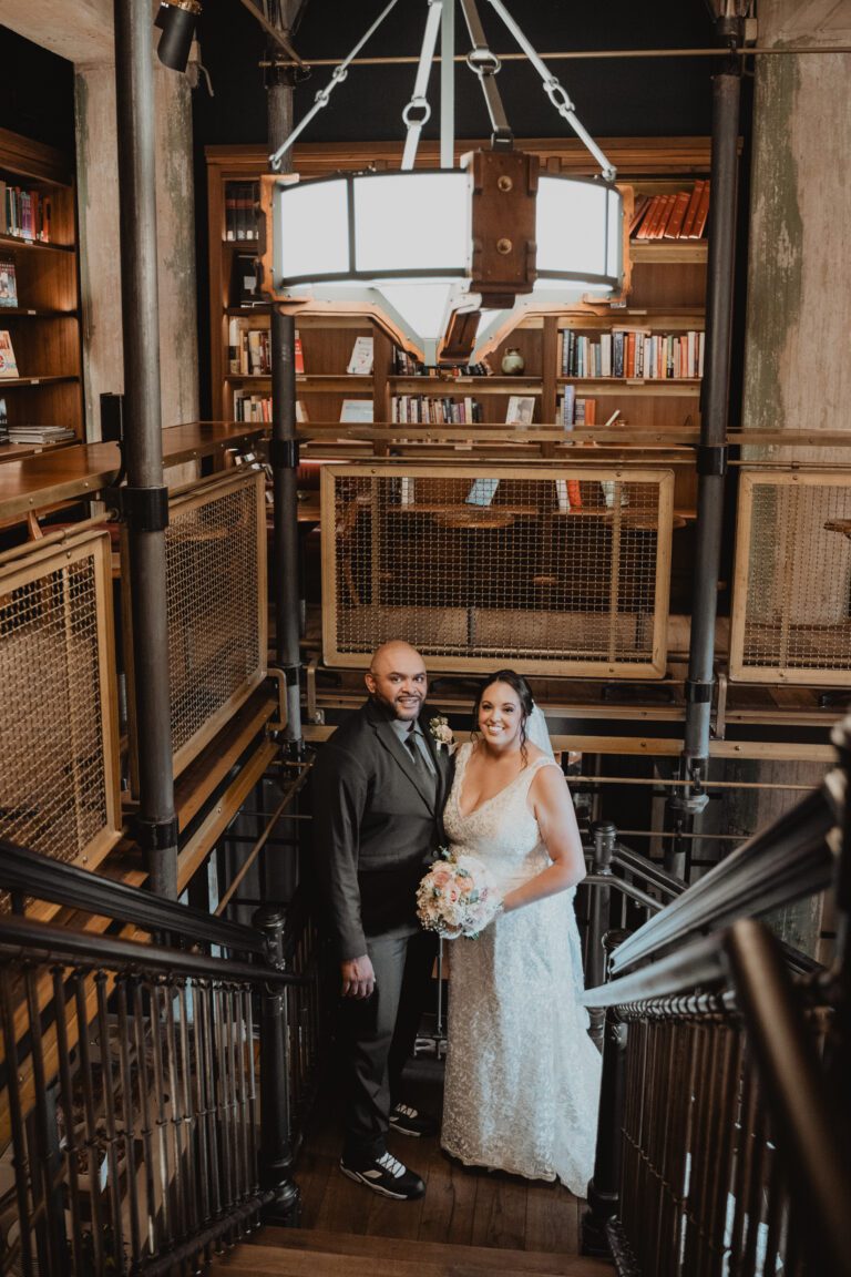 Bride and groom standing on the staircase inside Hotel Emma in San Antonio photographed by Bushel + Peck Photo.