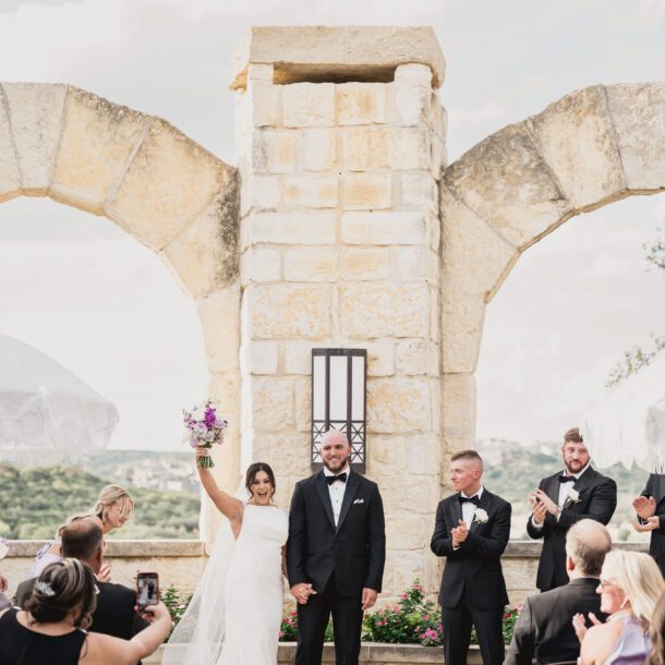 Bride standing beneath a stone arch with Hill Country views at La Cantera Resort in San Antonio photographed by Bushel + Peck Photo.