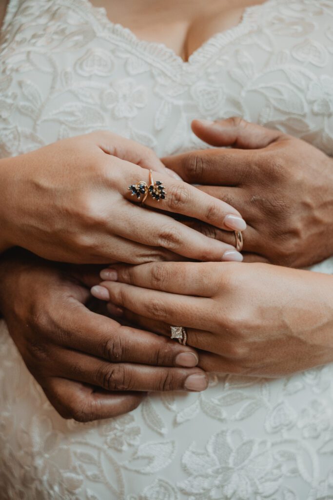 Close-up of the bride and groom's hands showing their wedding rings, captured by Bushel + Peck Photo