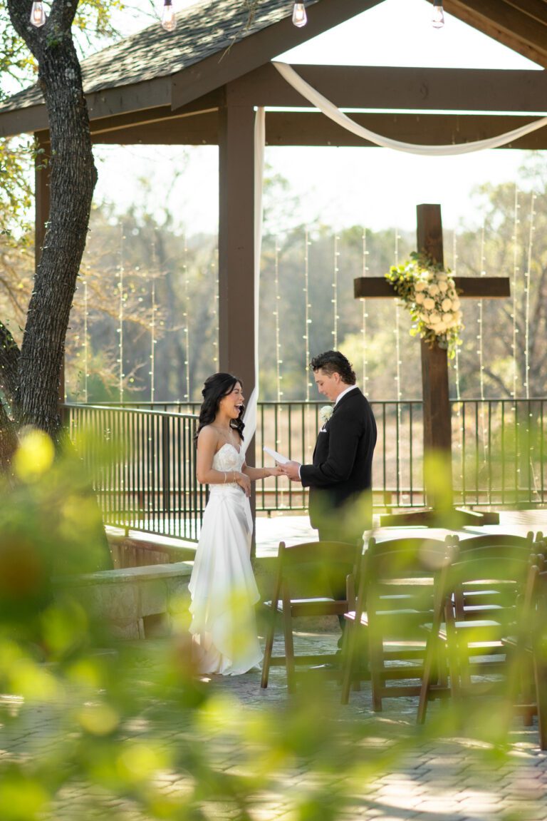 Bride and groom exchanging vows at The Ranch Austin ceremony pavilion photographed by Austin wedding photographers Bushel + Peck Photo.