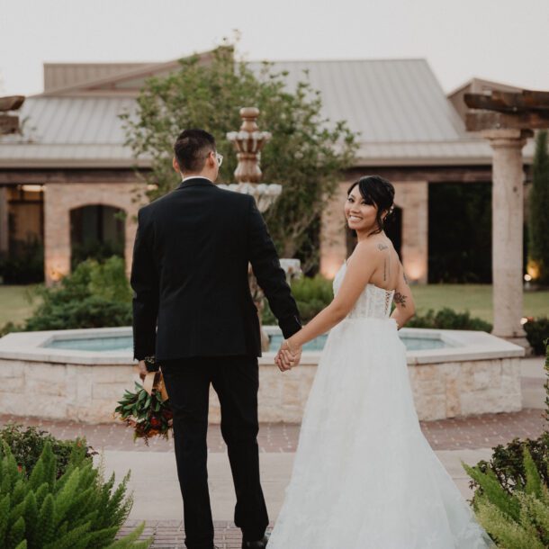 Bride and groom walking together outside St. Laurence Catholic Church in Houston during wedding portraits photographed by Bushel + Peck Photo