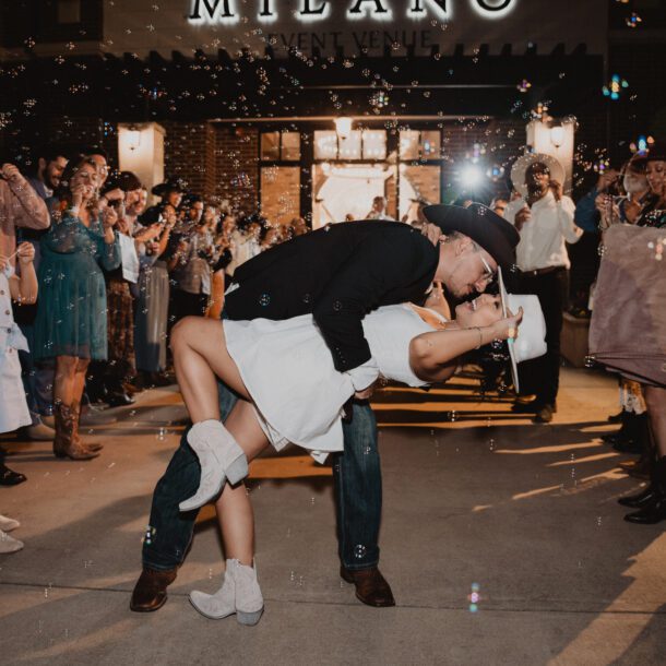 Bride and groom celebrating their wedding exit with guests and bubbles outside Milano Event Center in Texas photographed by Bushel + Peck Photo
