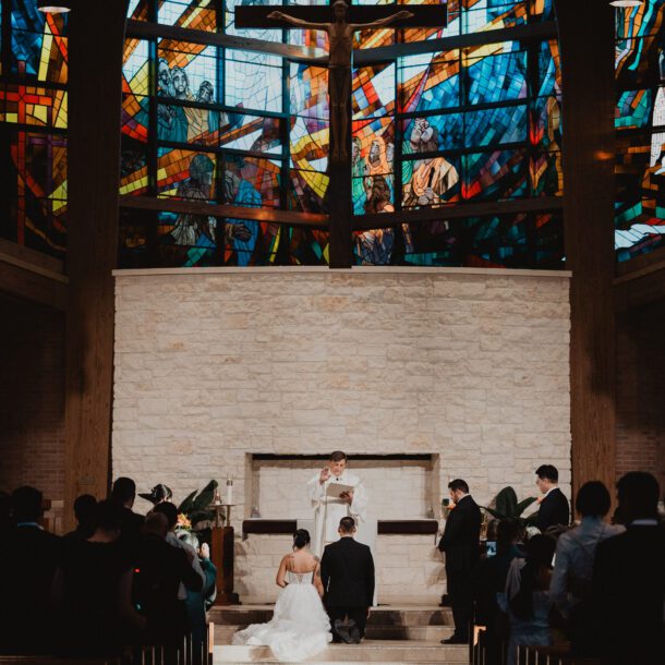 Bride and groom kneeling during Catholic wedding ceremony at St. Laurence Catholic Church in Houston photographed by Bushel + Peck Photo