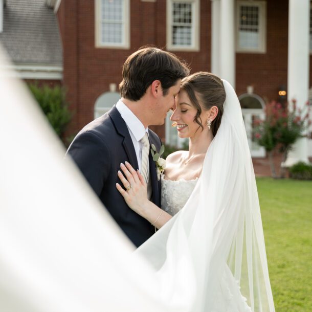 Bride and groom embracing in front of The Mansion at ColoVista columns photographed by Austin wedding photographers Bushel + Peck Photo.