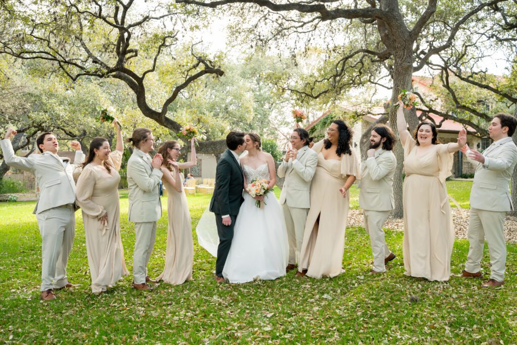 Bride and groom celebrating with their wedding party on the lawn at The Veranda in San Antonio, captured by Bushel + Peck Photo