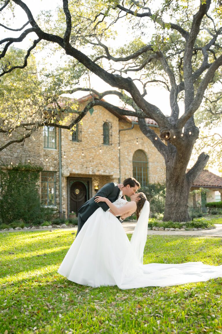 Bride and groom portraits in front of the historic stone building at The Veranda wedding venue in San Antonio photographed by Bushel + Peck Photo.