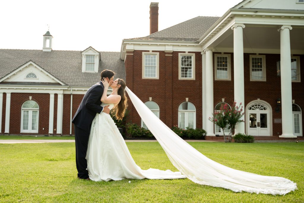 Bride and groom kissing in front of The Mansion at ColoVista near Austin photographed by Bushel + Peck Photo.