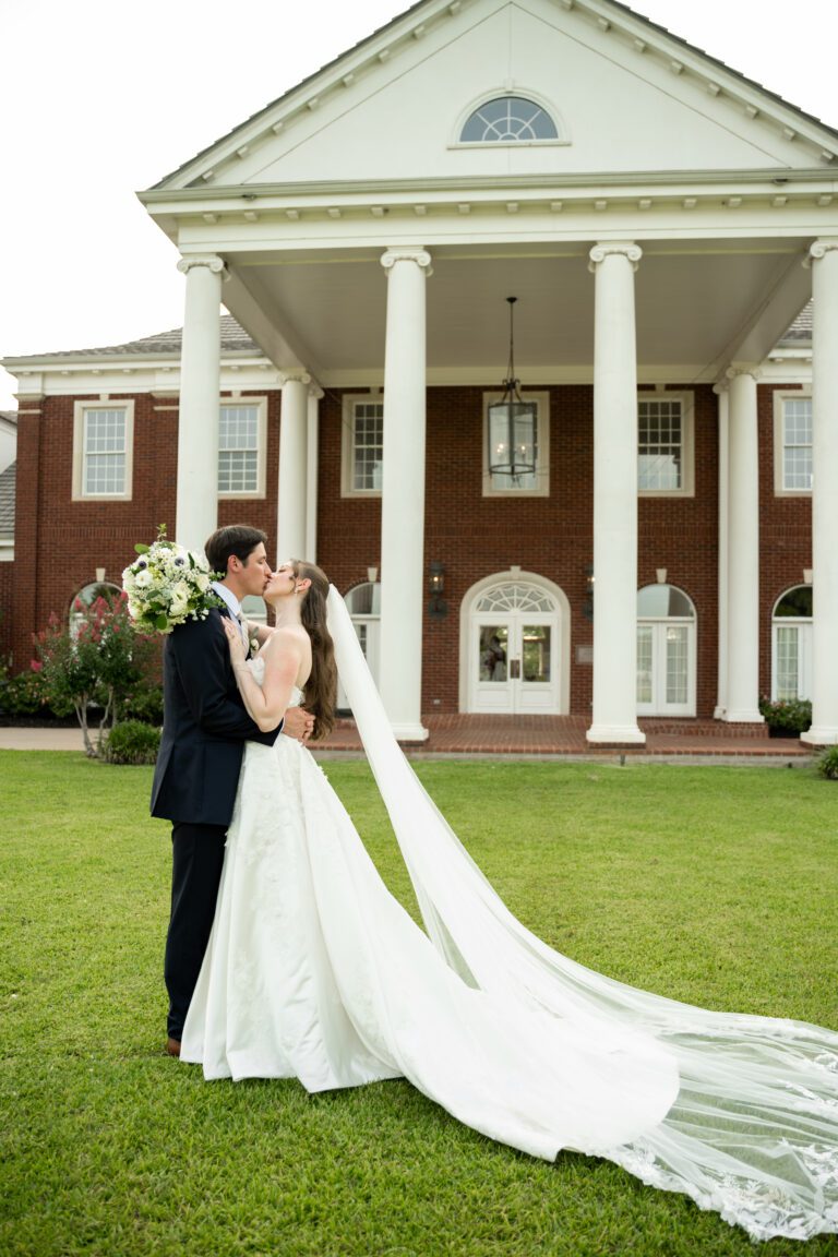 Bride and groom kissing in front of The Mansion at ColoVista near Austin photographed by Bushel + Peck Photo.