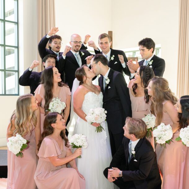 Bride and groom kiss surrounded by their wedding party at their downtown Fort Worth wedding — Bushel + Peck Photo Fort Worth wedding photographer