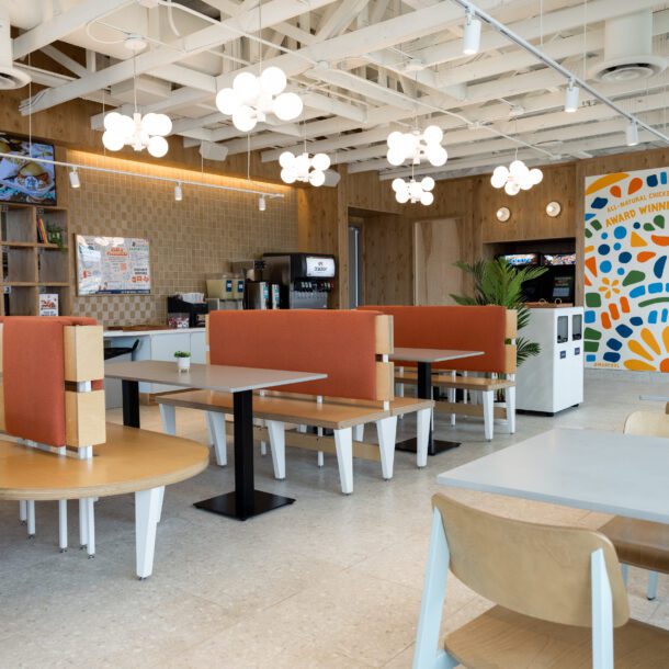 Colorful dining room with orange booths and a mosaic mural at the new Birdcall restaurant grand opening, captured by Bushel + Peck Photo.