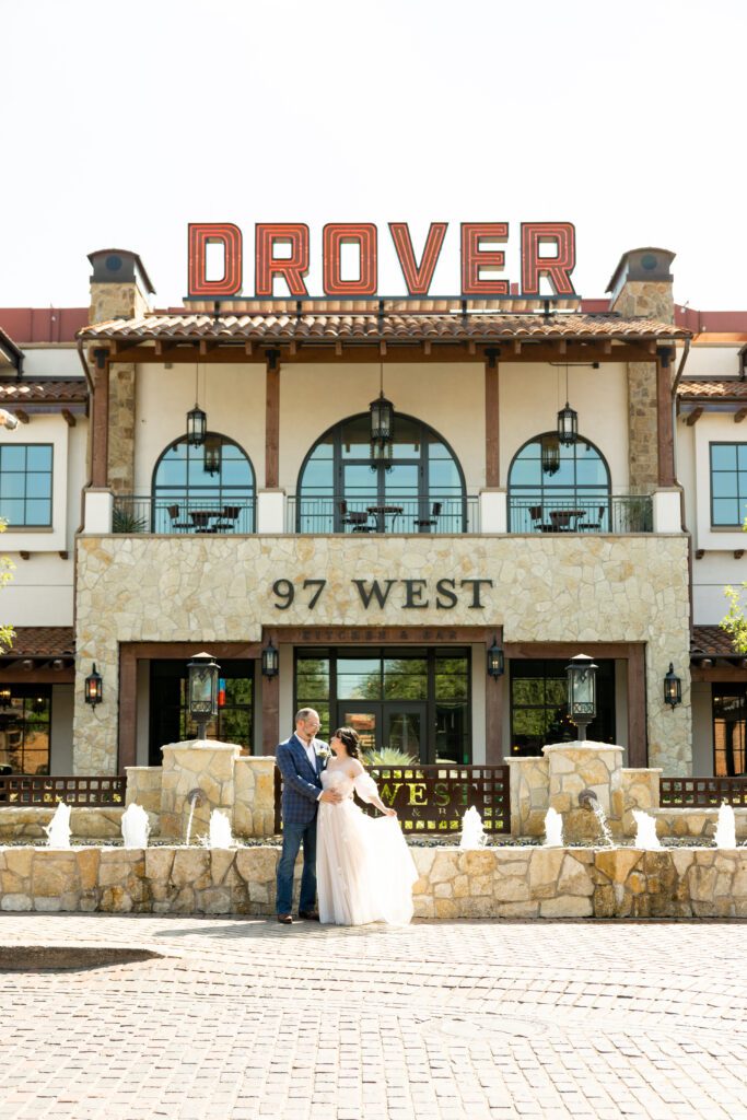 Newlyweds kissing in front of Hotel Drover in the Fort Worth Stockyards after their courthouse wedding, captured by Bushel + Peck Photo