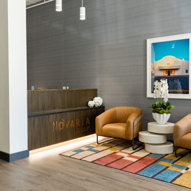Reception lobby with leather chairs and a Novaria Group logo wall at the Fort Worth headquarters, captured by Bushel + Peck Photo.