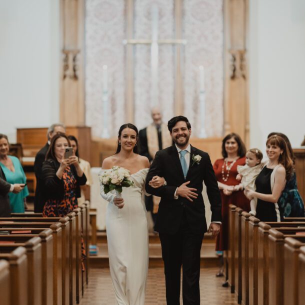 Bride and groom walking up the aisle at Highland Park United Methodist Church in Dallas after their micro wedding ceremony, captured by Bushel + Peck Photo