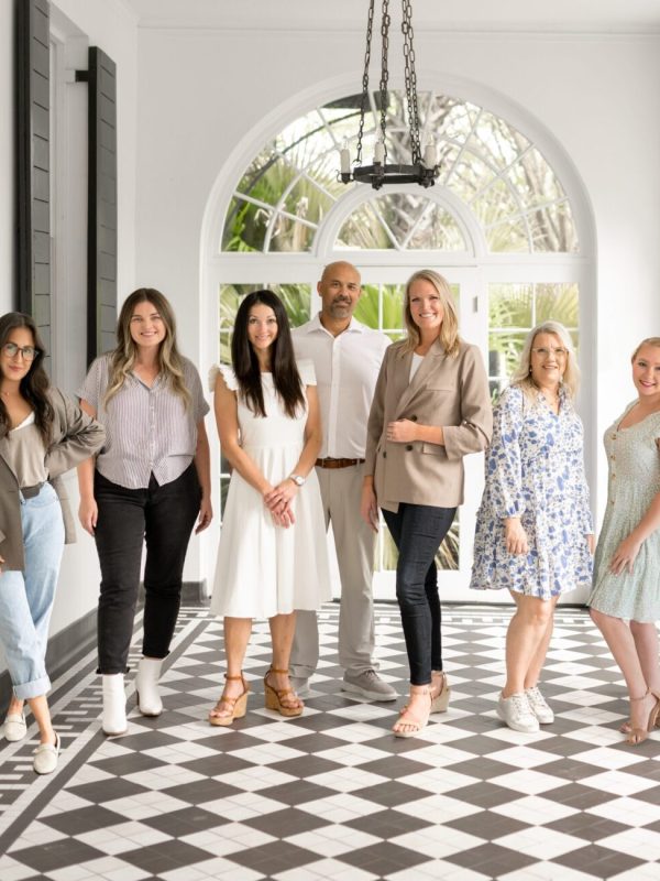 The Bushel + Peck Photo team of photographers standing together in a bright arched hallway