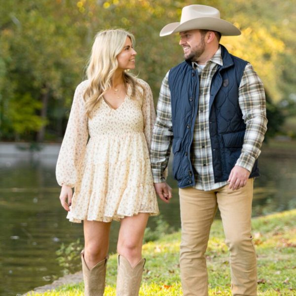 engagement session photo of couple walking, holding hands lakeside park. captured by Bushel + Peck Photo