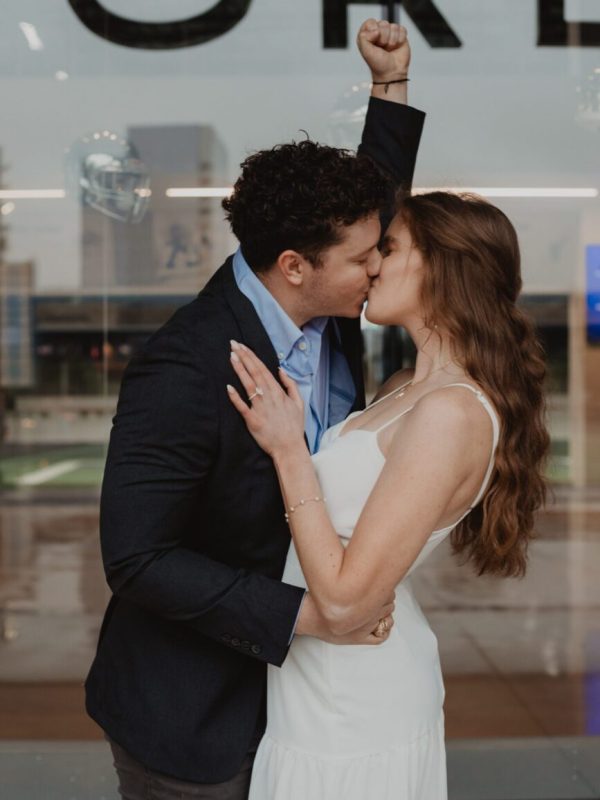 Couple celebrating engagement outside AT&T Stadium — Captured by Bushel + Peck Photo, Dallas Proposal Photographer