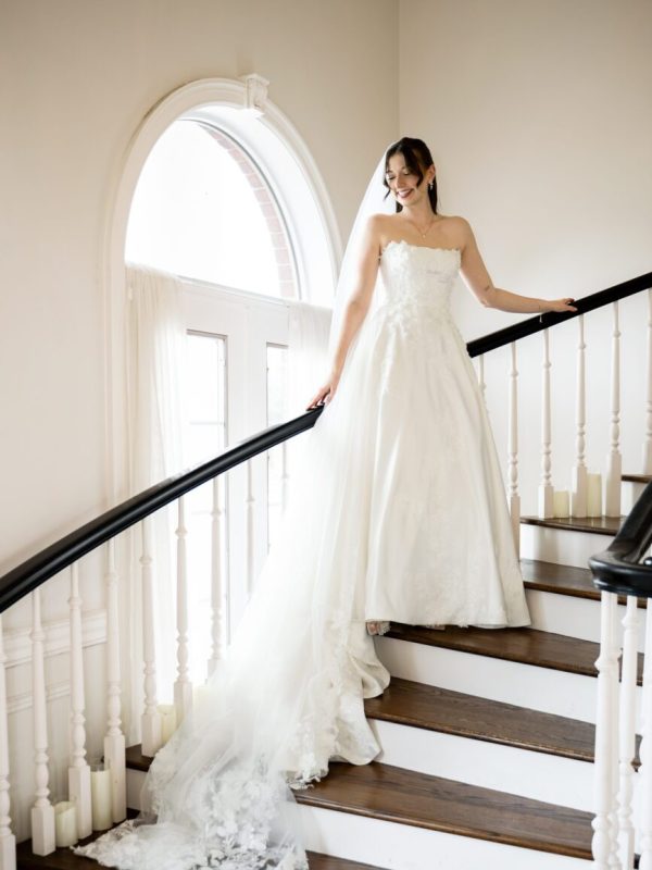 Bride posing on the grand staircase at The Mansion at ColoVista in Bastrop near Austin, captured by Bushel + Peck Photo